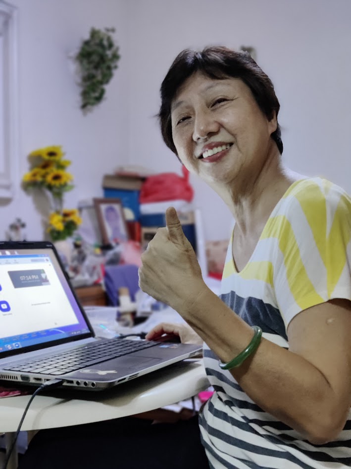 Satisfied PCExperts101 customer smiling and giving a thumbs up while working on a laptop, indicating successful PC repair or support service.