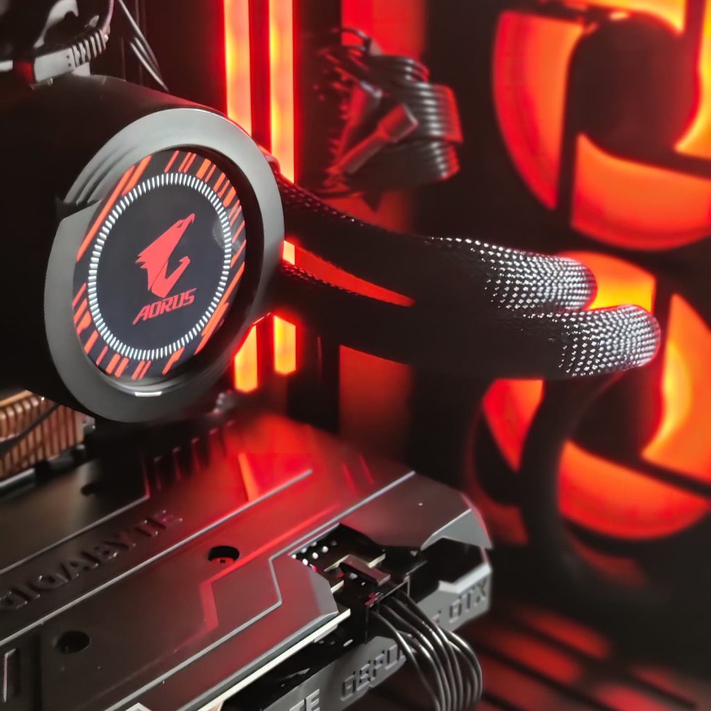 Close-up of AORUS liquid cooler and Gigabyte graphics card in a high-performance custom PC, featuring red RGB lighting, indicative of expert PC repair and custom PC building.