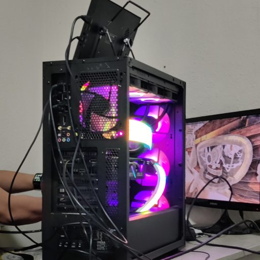 Rear view of a desktop PC with exposed cables and vibrant RGB lighting during a PC testing by PCExperts101.